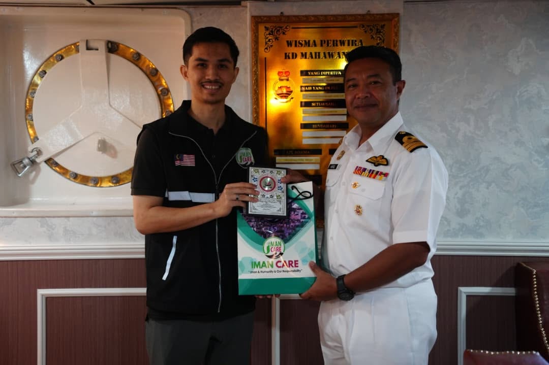 Wakil Iman Care menyerahkan cenderamata kepada pegawai TLDM